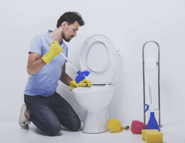 uomo che tenta rimedi per scarico wc ostruito